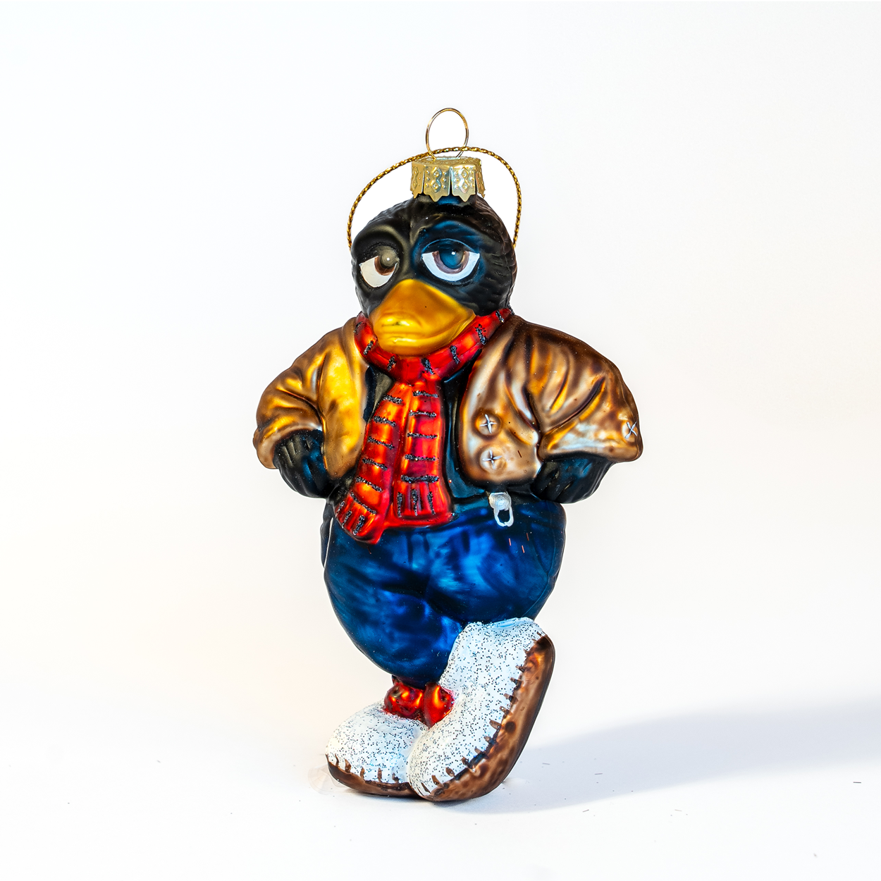 Solan julekule fra HEIM Studio – håndmalt glassfigur av den selvsikre skjæra fra Flåklypa, med rødt skjerf, brun jakke og grå tovete tøfler.