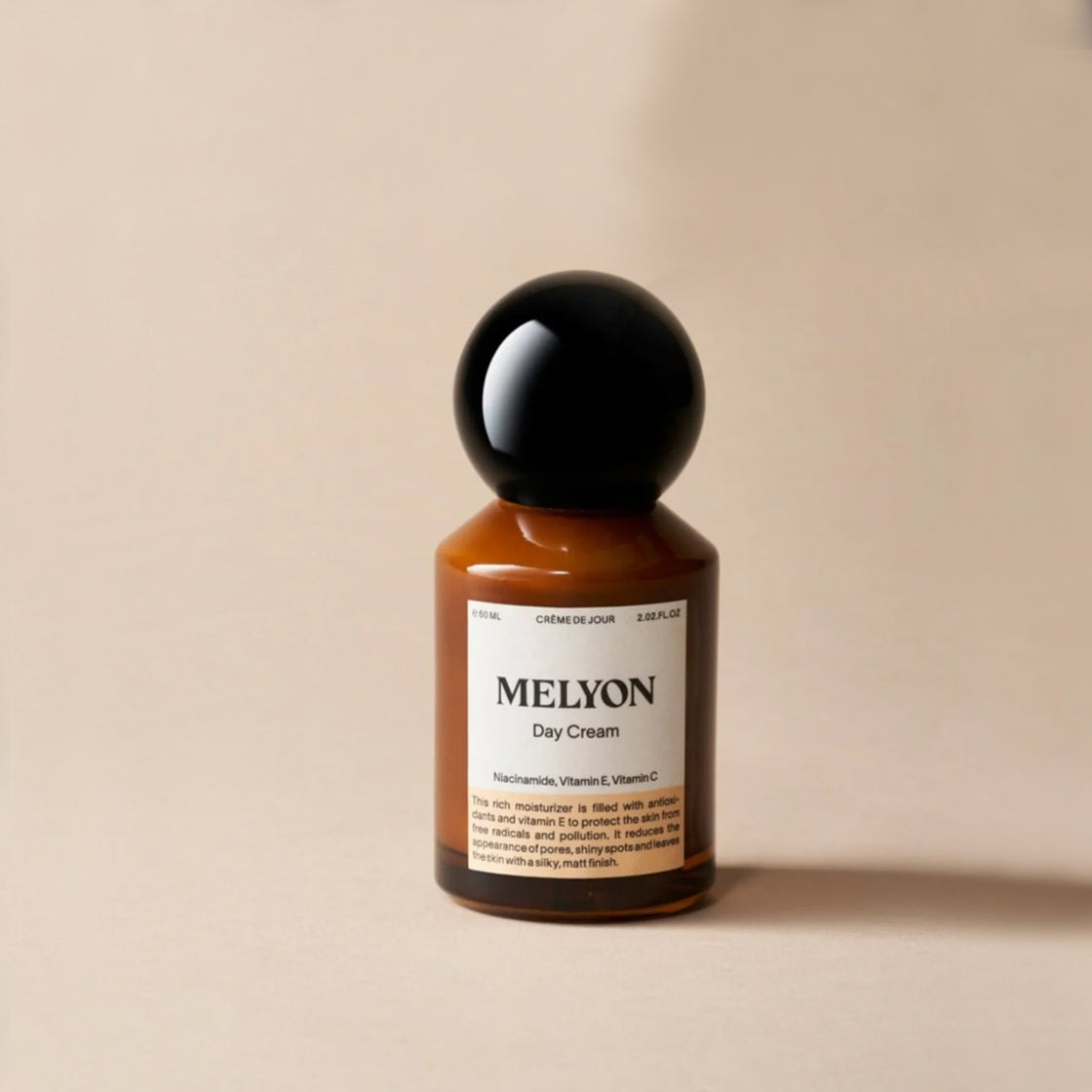 Brunt glassflaske med sort runde lokk for Dagkrem c-vitamin 60 ML - By Melyon på lys beige bakgrunn