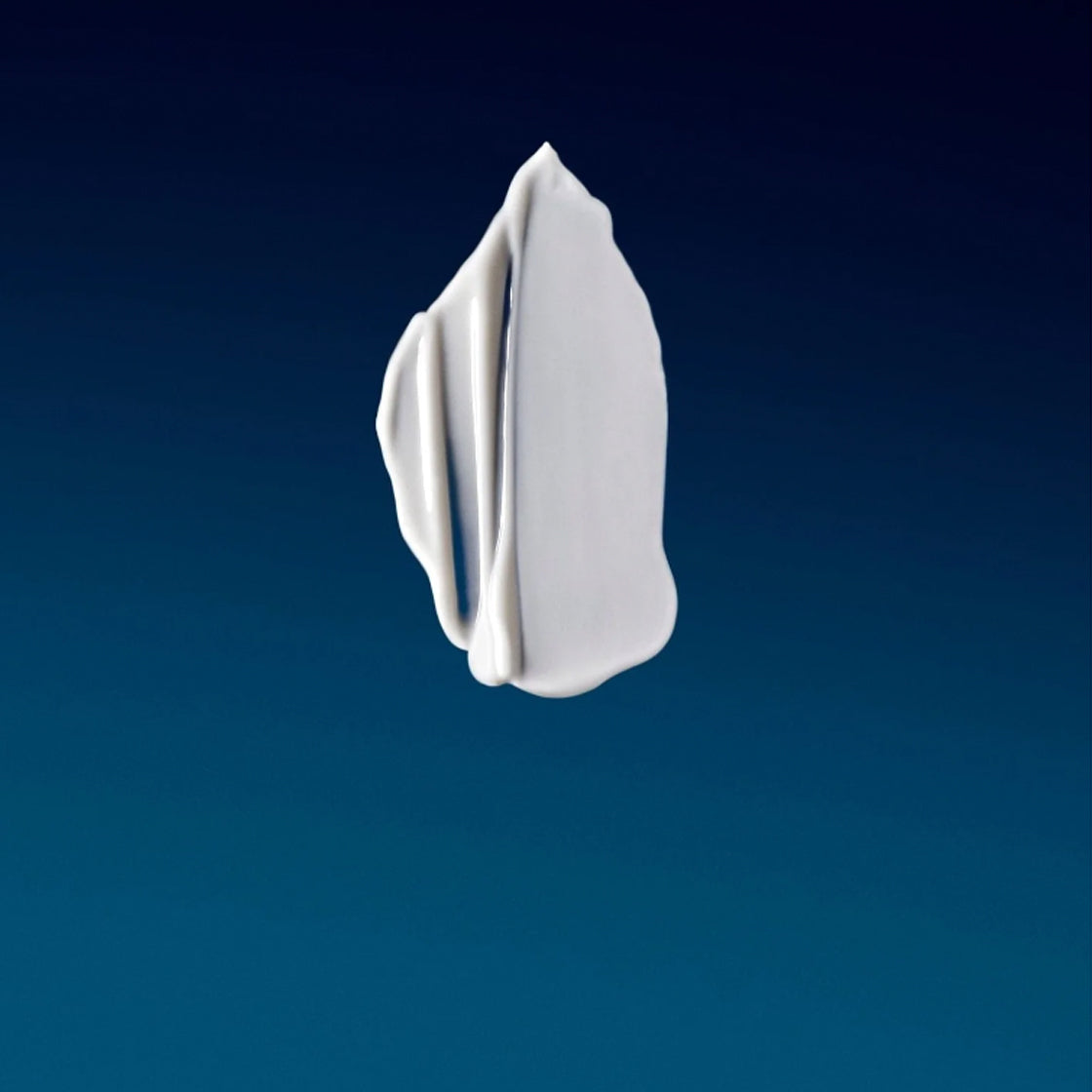 Kremet, hvit tekstur på blågrå bakgrunn for Milk Cleaner 60 ML - By Melyon med myk konsistens