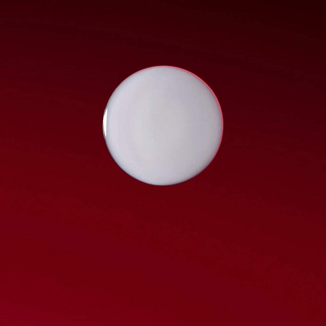 Dråpe av Detox Serum 60 ML - By Melyon på dyp rød bakgrunn med fokus på tekstur og fargekontrast