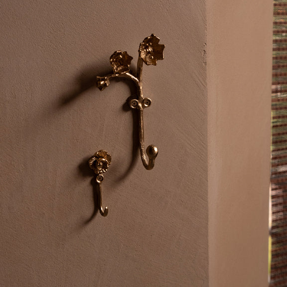 Ava Blomster Krok - By Doing Goods i resirkulert messing med blomsterdetaljer på vegg i nøytral tone