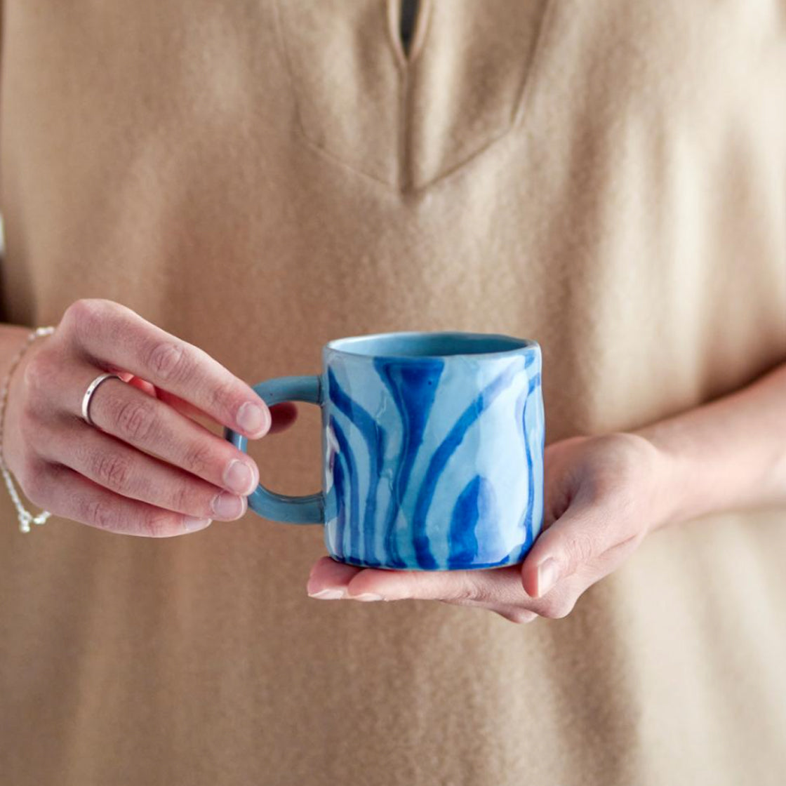 Krus Nina Blå - By Bloomingville med blått retro mønster holdt i hender mot nøytral bakgrunn