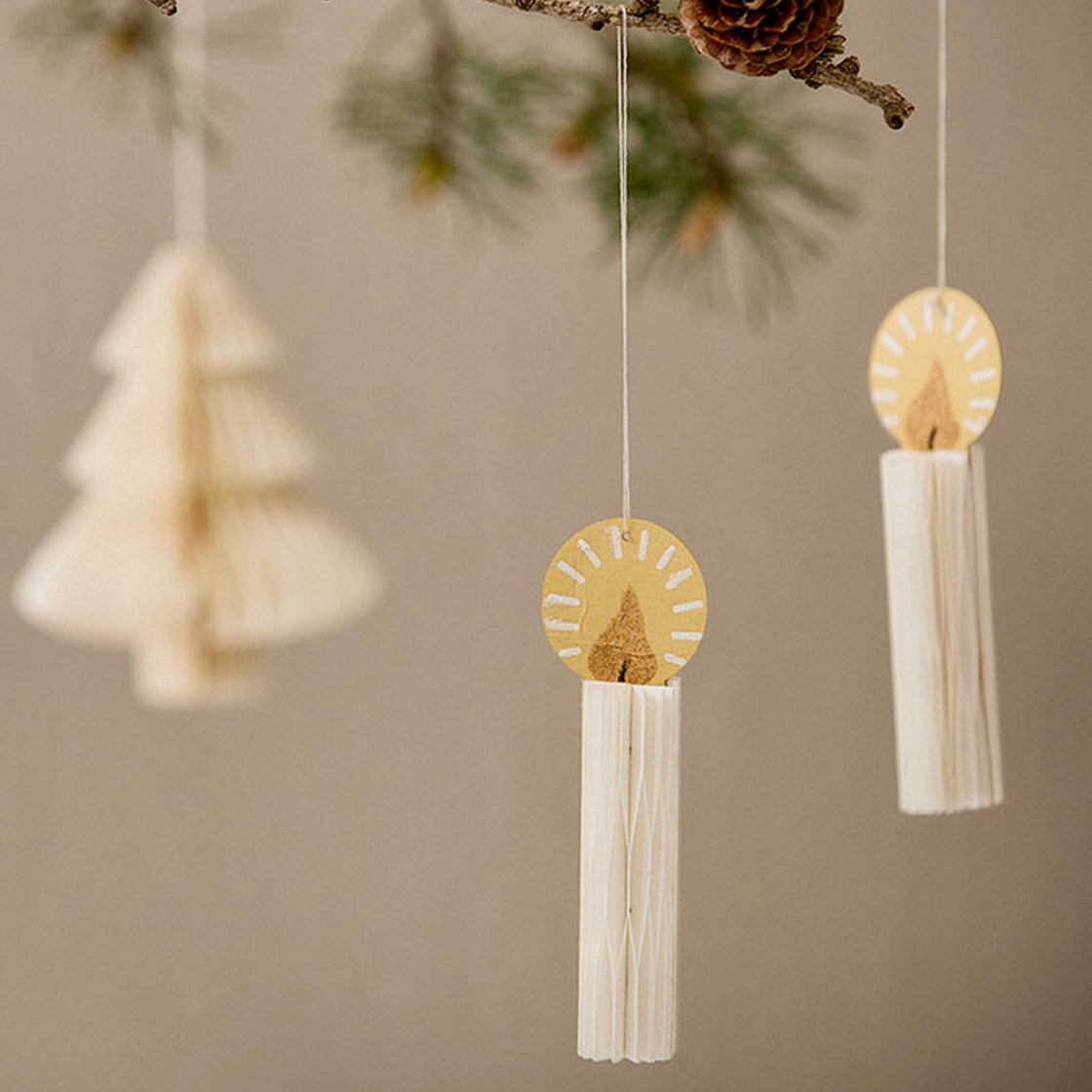 Lys i Papir 3 stk. - By Bungalow med bikakeformede, foldbare lys og gullglitterdetaljer hengt i snor.