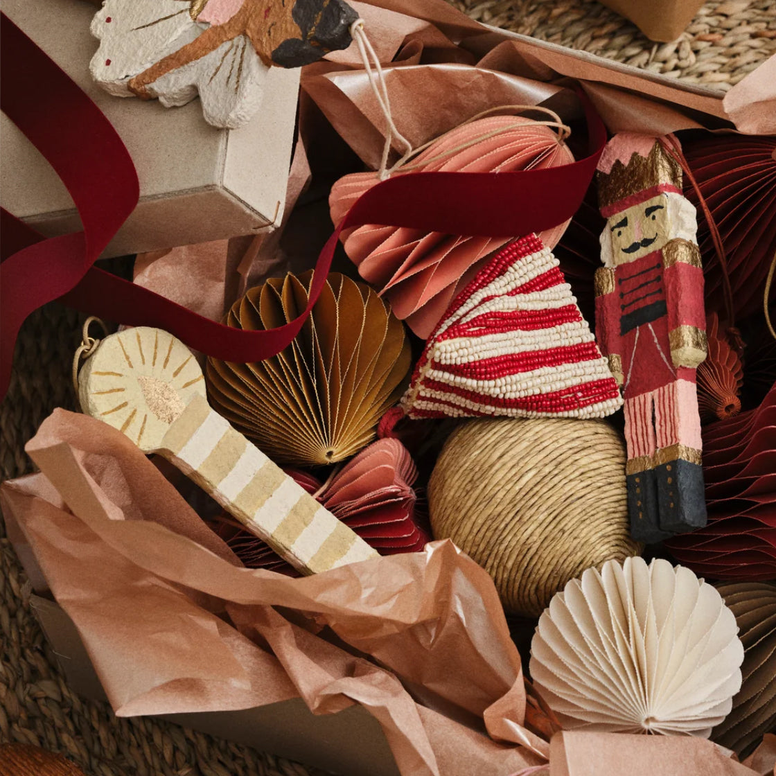 Lys laget i Pappmasje - By Broste Copenhagen vist sammen med juledekorasjoner i varme farger på brun bakgrunn