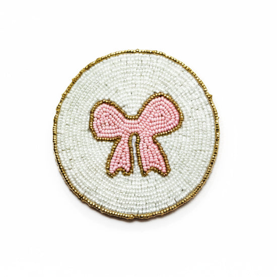 Drikkebrikker Rosa Sløyfe - By HEIM Studio med perler i rosa sløyfe og hvit bakgrunn med gullkanter