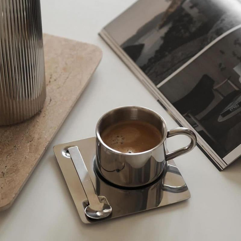 Kaffekopp i stål - by Heim design med firkantet fat og matchende skje i stilrent og robust utførsel på bord