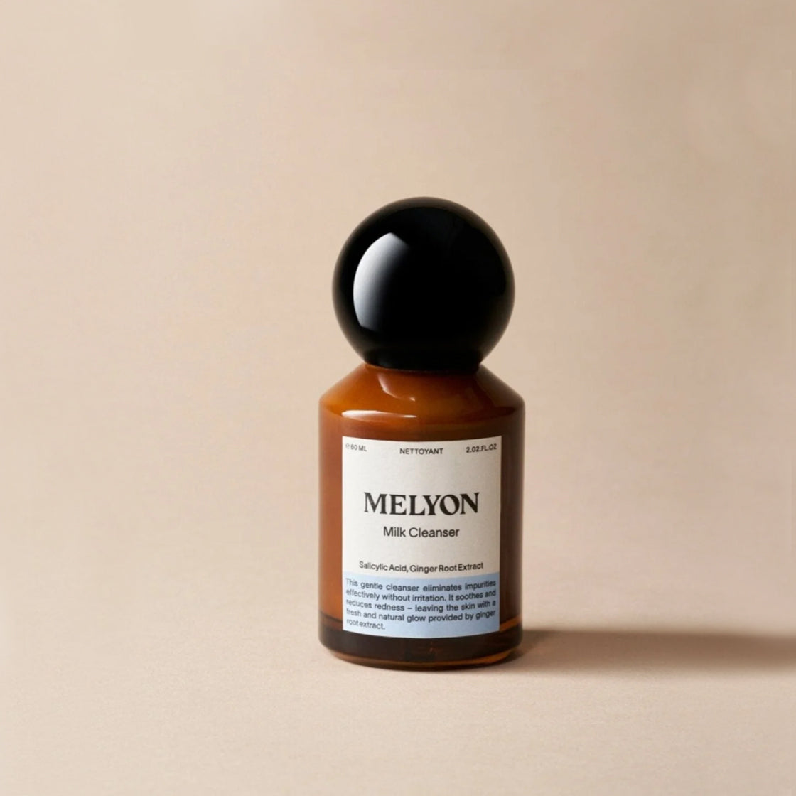 Flaske i brunt glass med svart kuleformet lokk for Milk Cleaner 60 ML - By Melyon på nøytral beige bakgrunn