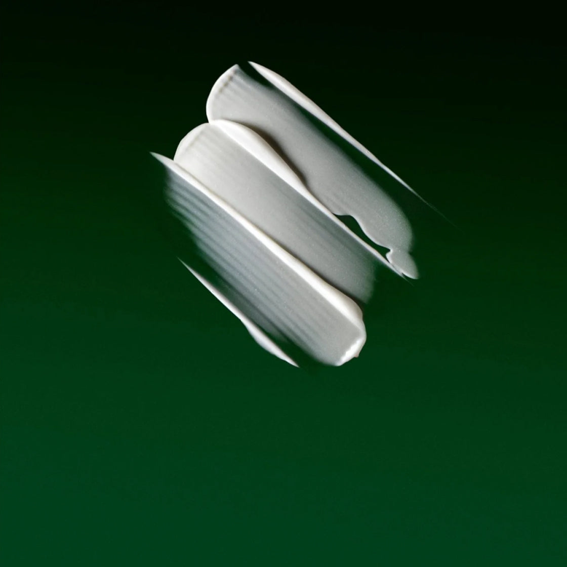 Kremtekstur på mørk grønn bakgrunn for Nattkrem Vitamin-A 60 ML - By Melyon med myk og jevn finish