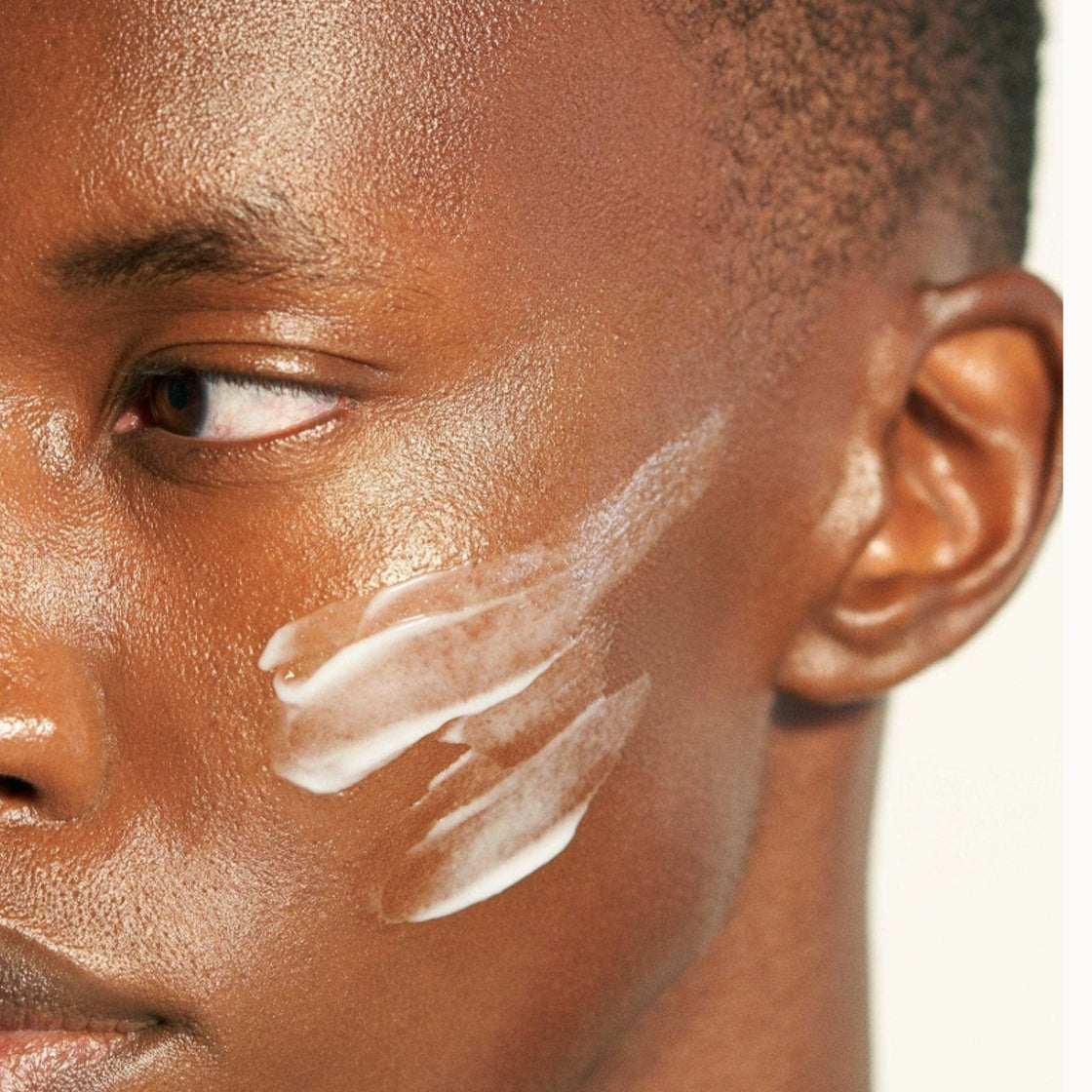 Nærbilde av person med kremstriper på kinn i naturlig lys for Milk Cleaner 60 ML - By Melyon